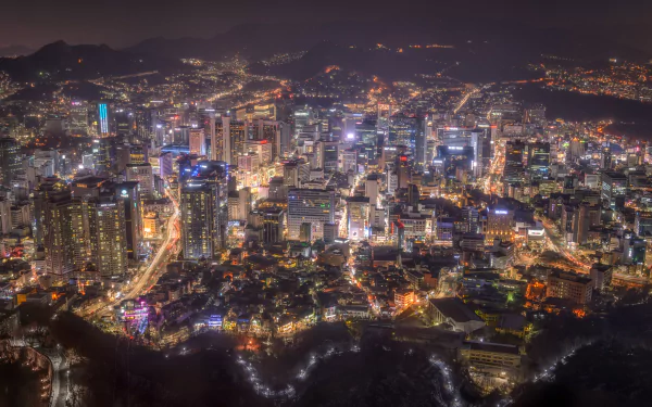 HD desktop wallpaper of a stunning night cityscape in Seoul, Korea, showcasing the dazzling lights and towering structures of the megapolis.
