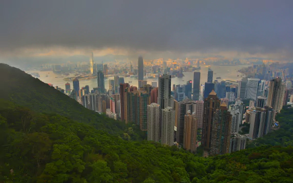 Fog envelops the megapolis of Hong Kong, with Victoria Harbour visible beneath a dramatic sky, captured in a 4K Ultra HD cityscape landscape.