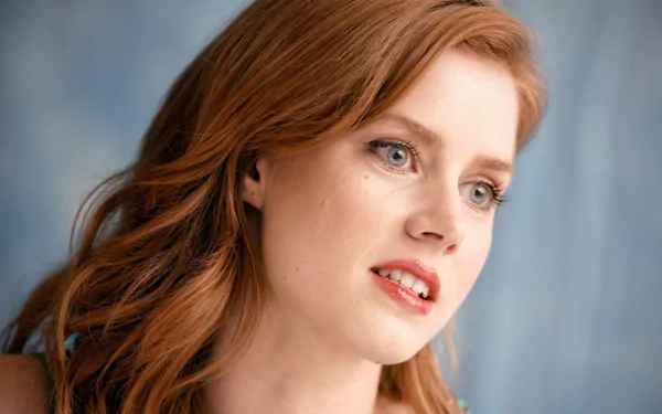 Close-up of redhead actress Amy Adams with soft lighting, featured as an HD PC desktop wallpaper and background.