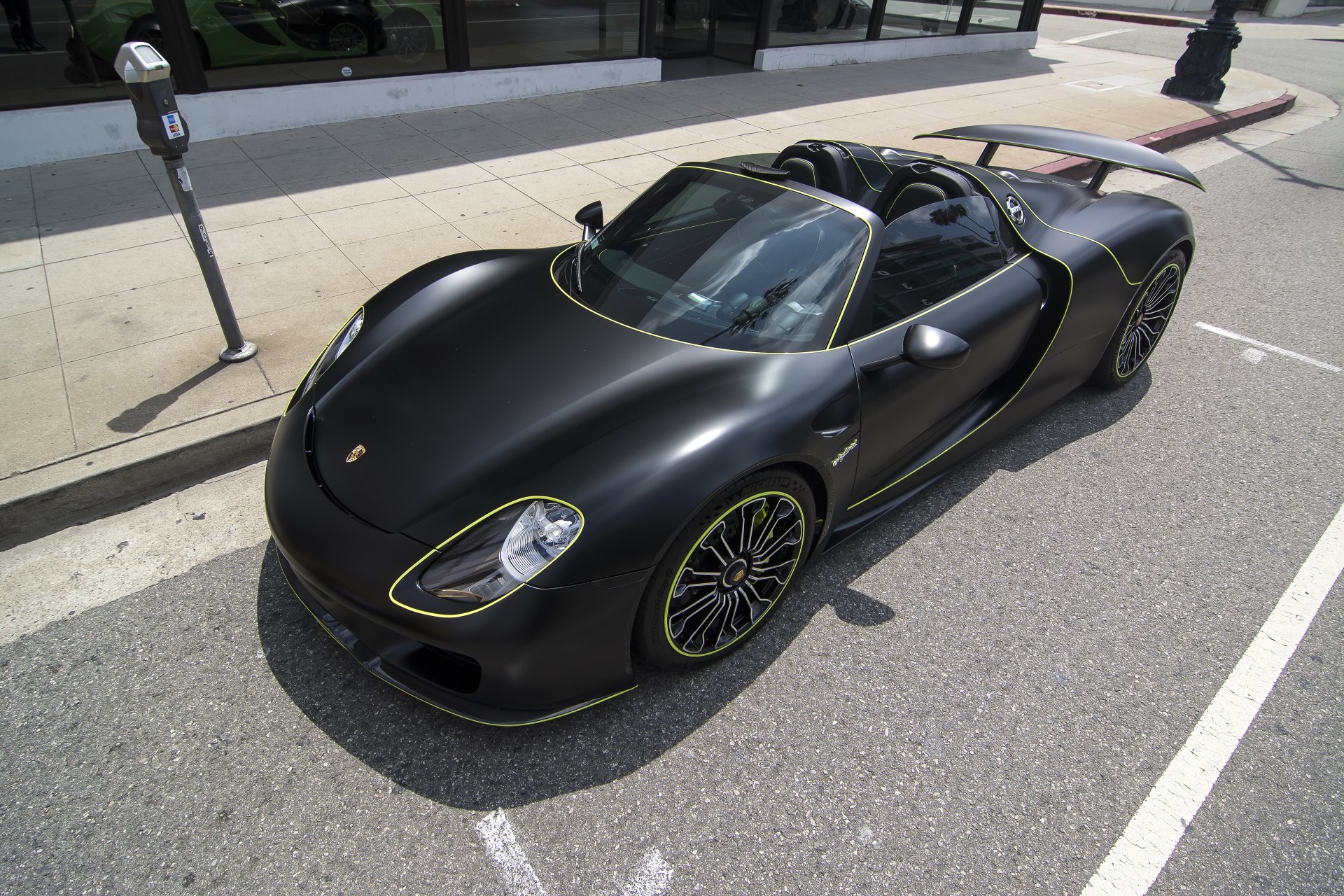 Black Porsche 918 Spyder supercar parked on a city street, showcased in stunning 4K Ultra HD as a sleek vehicle desktop wallpaper.