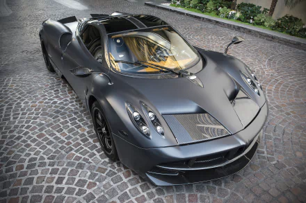 A striking Pagani Huayra in sleek silver parked on a cobblestone street, showcasing its luxurious design and high-performance features. The image captures the essence of a supercar in stunning detail.