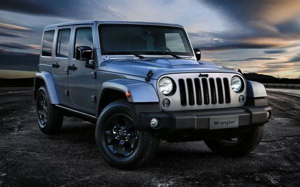A Jeep Wrangler stands confidently against a dramatic sky, showcasing its robust 4x4 design in this stunning 4K Ultra HD desktop wallpaper.