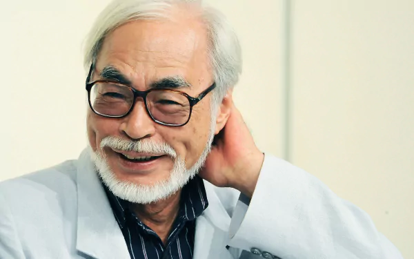 HD desktop wallpaper featuring a smiling, bespectacled person related to Hayao Miyazaki.