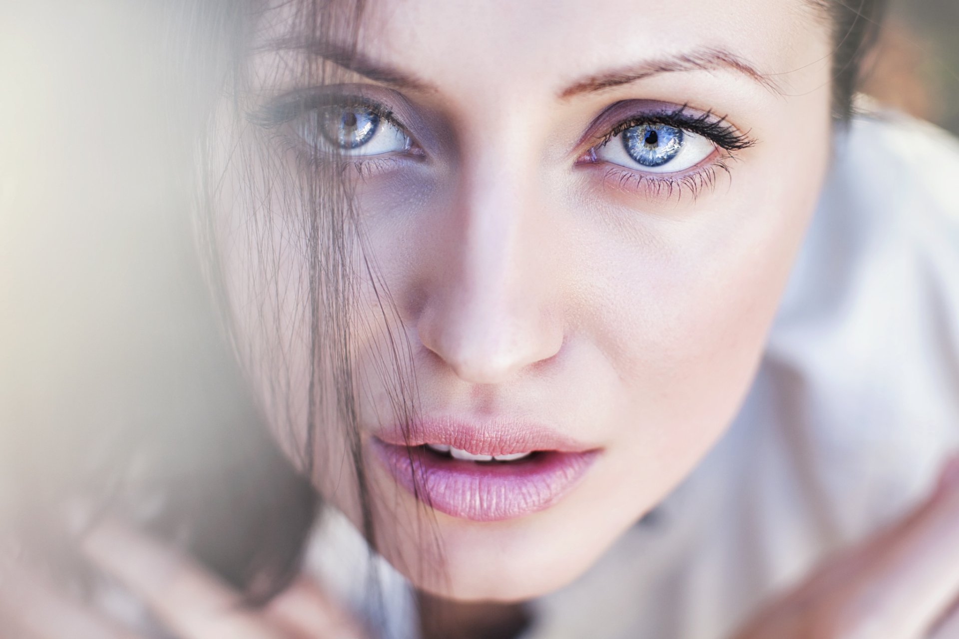 Close-up of a brunette model with striking blue eyes and natural makeup, captured in HD for a vibrant PC desktop wallpaper and background.