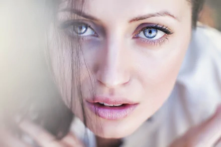Close-up of a brunette model with striking blue eyes and natural makeup, captured in HD for a vibrant PC desktop wallpaper and background.