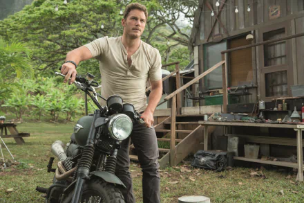 HD desktop wallpaper featuring Chris Pratt from Jurassic World, standing next to a motorcycle in a rustic outdoor setting.