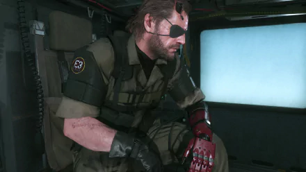 Big Boss from Metal Gear Solid V: The Phantom Pain sits thoughtfully in a helicopter, showcasing his iconic look in this HD PC desktop wallpaper and background.