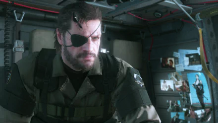A detailed HD wallpaper featuring Big Boss from Metal Gear Solid V: The Phantom Pain, depicting him deep in thought amidst a backdrop of military gear and personal photos.