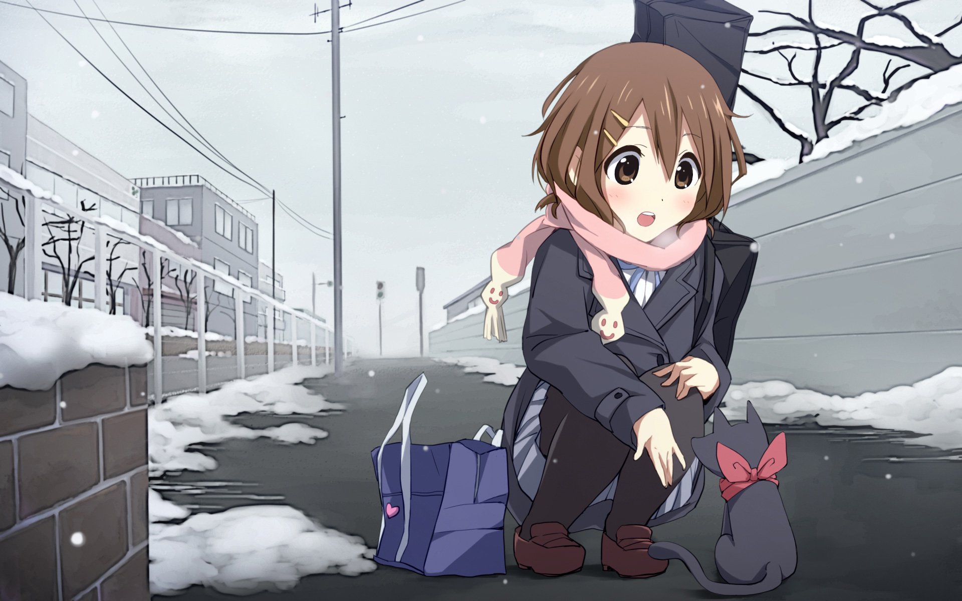 HD PC desktop wallpaper featuring Yui Hirasawa from the anime K-ON!, crouching on a snowy street with a gray cat and her guitar case in the background.