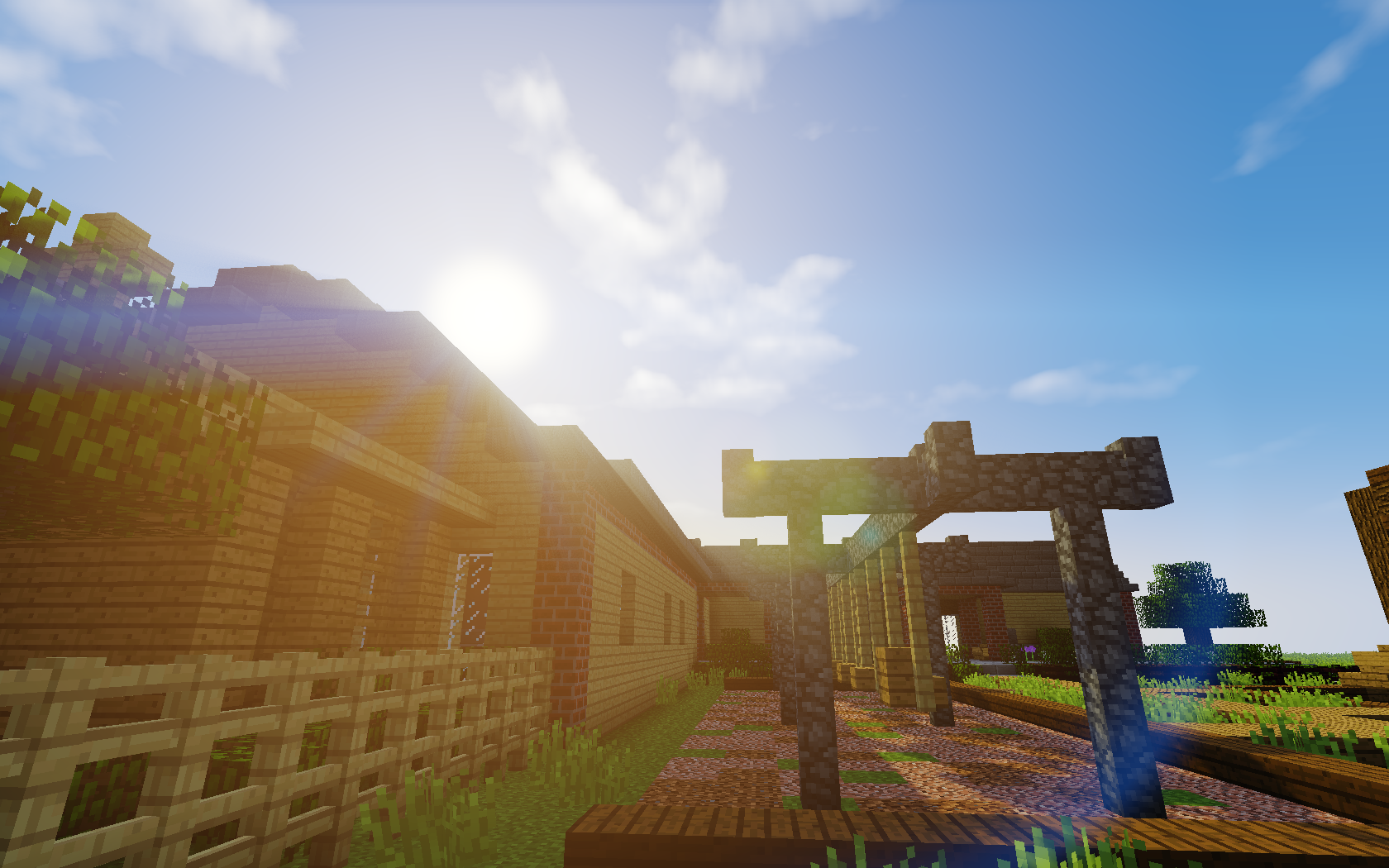 A vibrant Minecraft scene featuring wooden buildings beneath a bright sky, with sunlight streaming down and a charming pathway, making it an engaging HD desktop wallpaper.