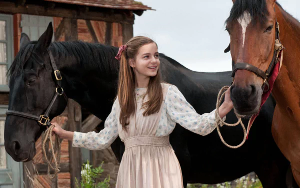 HD PC desktop wallpaper from the movie War Horse: young woman in period dress smiling between two horses outside a rustic farmhouse.
