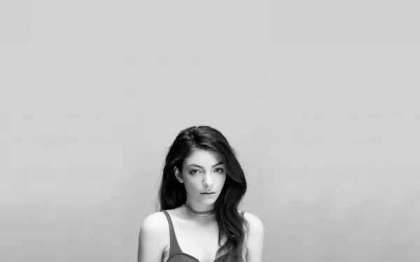 Black and white HD desktop wallpaper featuring singer Lorde with a neutral background, highlighting her intense gaze and flowing hair.