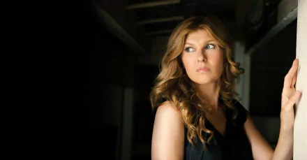 HD desktop wallpaper featuring Connie Britton from the TV show American Horror Story, captured in a dramatic, moody setting with soft lighting.