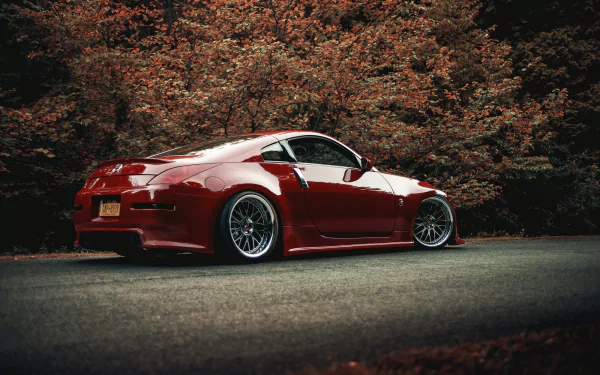HD PC desktop wallpaper and background: red Nissan 350Z vehicle with lowered stance and aftermarket wheels parked against autumn foliage.