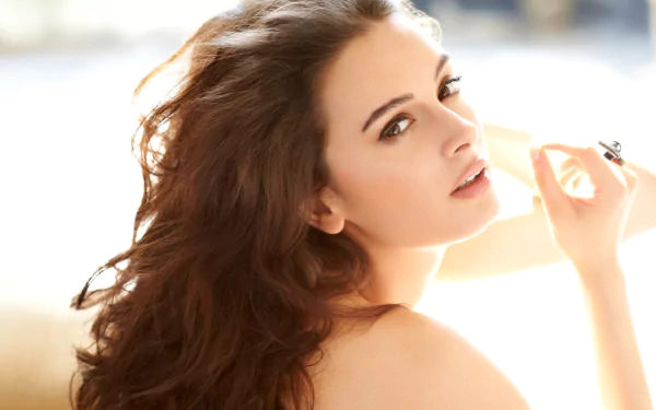 A high-definition wallpaper featuring Evelyn Sharma, showcasing her elegant pose and radiant beauty against a soft, light-filled background.