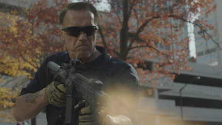 Arnold Schwarzenegger aiming a rifle in a scene from the 2014 movie Sabotage, featured as an HD PC desktop wallpaper background.