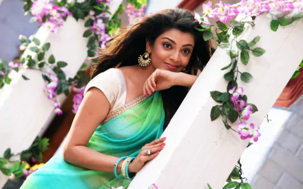 Kajal Aggarwal poses elegantly in a vibrant green sari surrounded by flowers, showcasing a scene from the movie *Jilla*. This HD image serves as a striking desktop wallpaper.