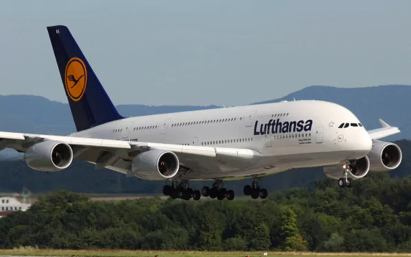 An Airbus A380 from Lufthansa descends towards the runway, set against a scenic backdrop. This high-definition image serves as a striking desktop wallpaper.