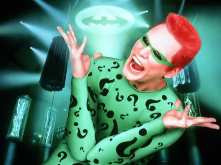 HD desktop wallpaper featuring Jim Carrey as the Riddler from the movie Batman Forever, posing with a bright smile against the Bat-Signal in the background.