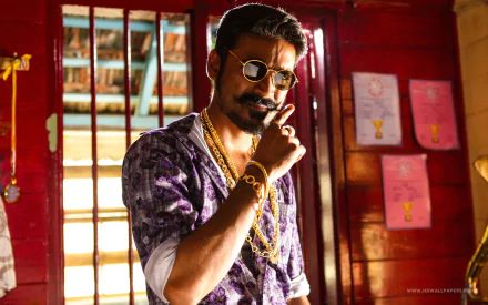 A striking HD wallpaper featuring Dhanush from the movie Maari, showcasing his stylish look with sunglasses and jewelry in a vibrant, colorful setting.