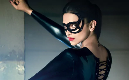 Deepika Padukone, the Indian actress and model, poses dramatically in a sleek black outfit and mask, creating a striking HD desktop wallpaper background.