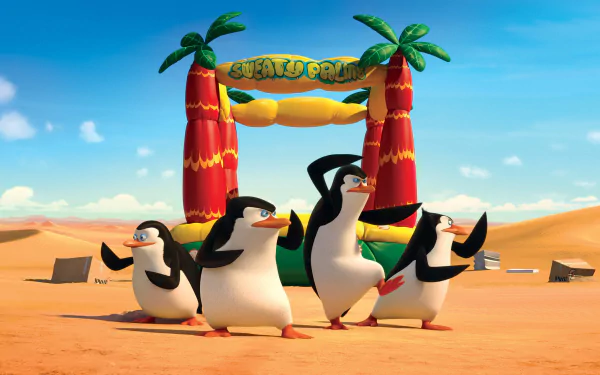 HD PC desktop wallpaper featuring the Penguins of Madagascar dancing under a tropical-themed Welcome Point arch in a desert landscape.