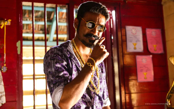 A striking HD wallpaper featuring Dhanush from the movie Maari, showcasing his stylish look with sunglasses and jewelry in a vibrant, colorful setting.