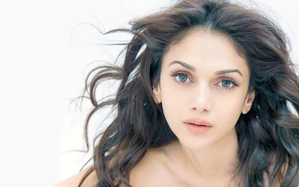 HD desktop wallpaper featuring celebrity Aditi Rao Hydari with flowing hair and a serene expression against a light background.