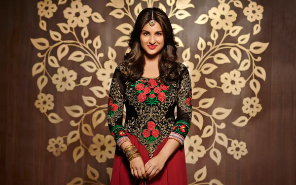 A glamorous Parineeti Chopra poses in a beautifully detailed embroidered outfit against a floral backdrop, serving as an elegant HD desktop wallpaper and background.
