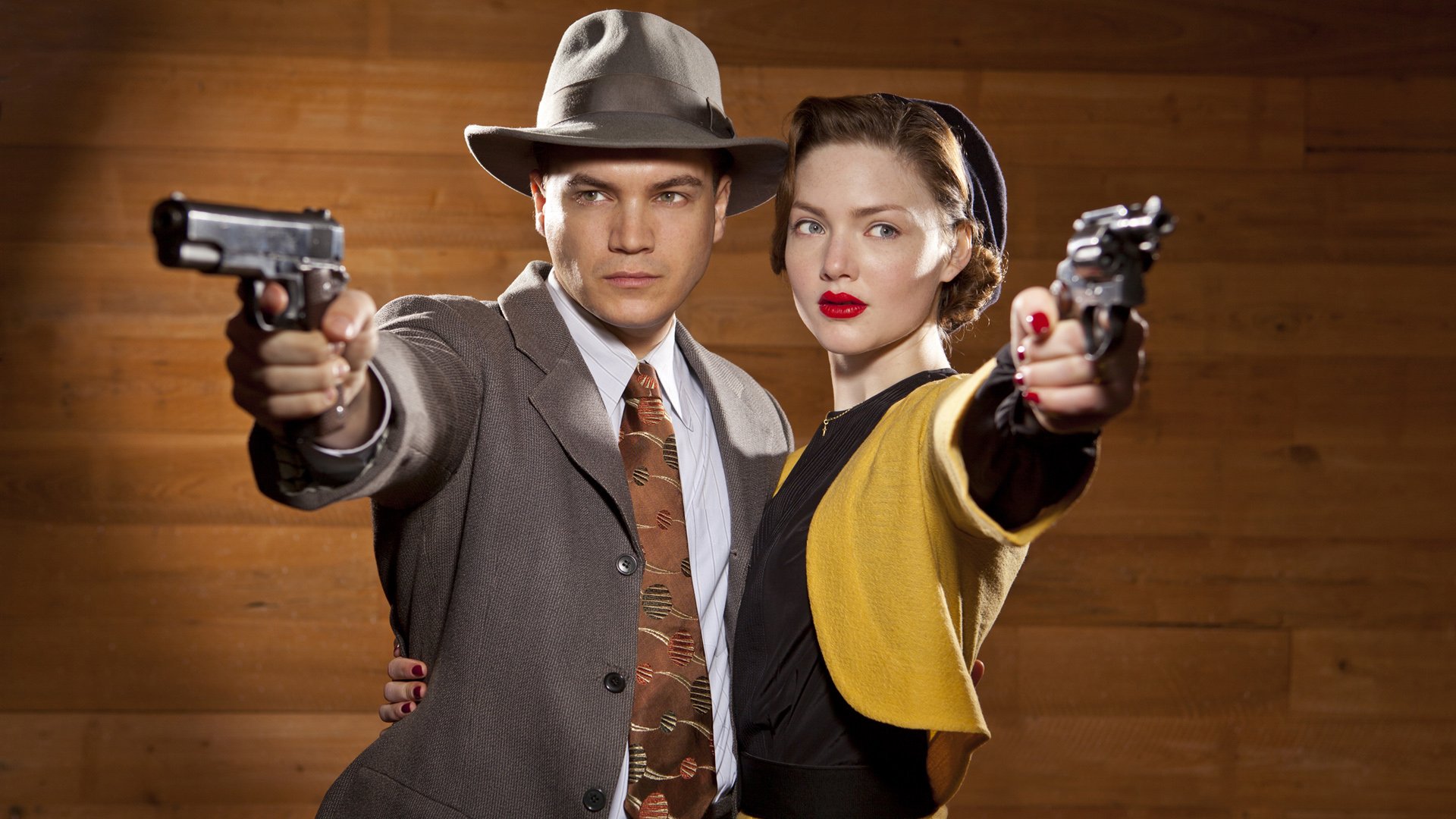 HD PC desktop wallpaper and background: TV show Bonnie & Clyde — 1930s–style couple in period clothing aim pistols at the viewer against a wooden backdrop.