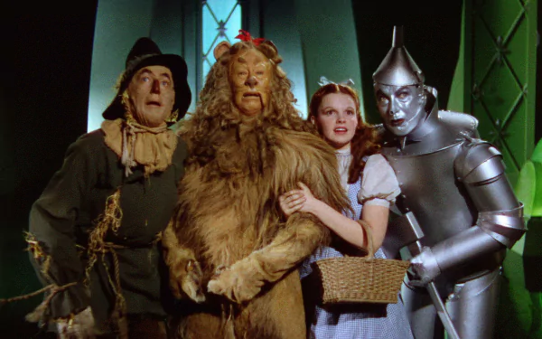 A colorful scene from the classic movie The Wizard of Oz (1939), featuring Dorothy and her companions: the Scarecrow, Cowardly Lion, and Tin Man, smiling together in a whimsical setting.