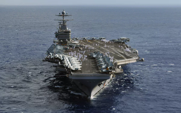 Bow-on view of aircraft carrier USS Abraham Lincoln (CVN-72) underway with fighter jets lined along the flight deck, HD PC desktop wallpaper.
