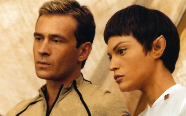 HD PC desktop wallpaper: two Star Trek: Enterprise crew members in beige uniforms, close-up dramatic portrait with a neutral, softly lit backdrop.