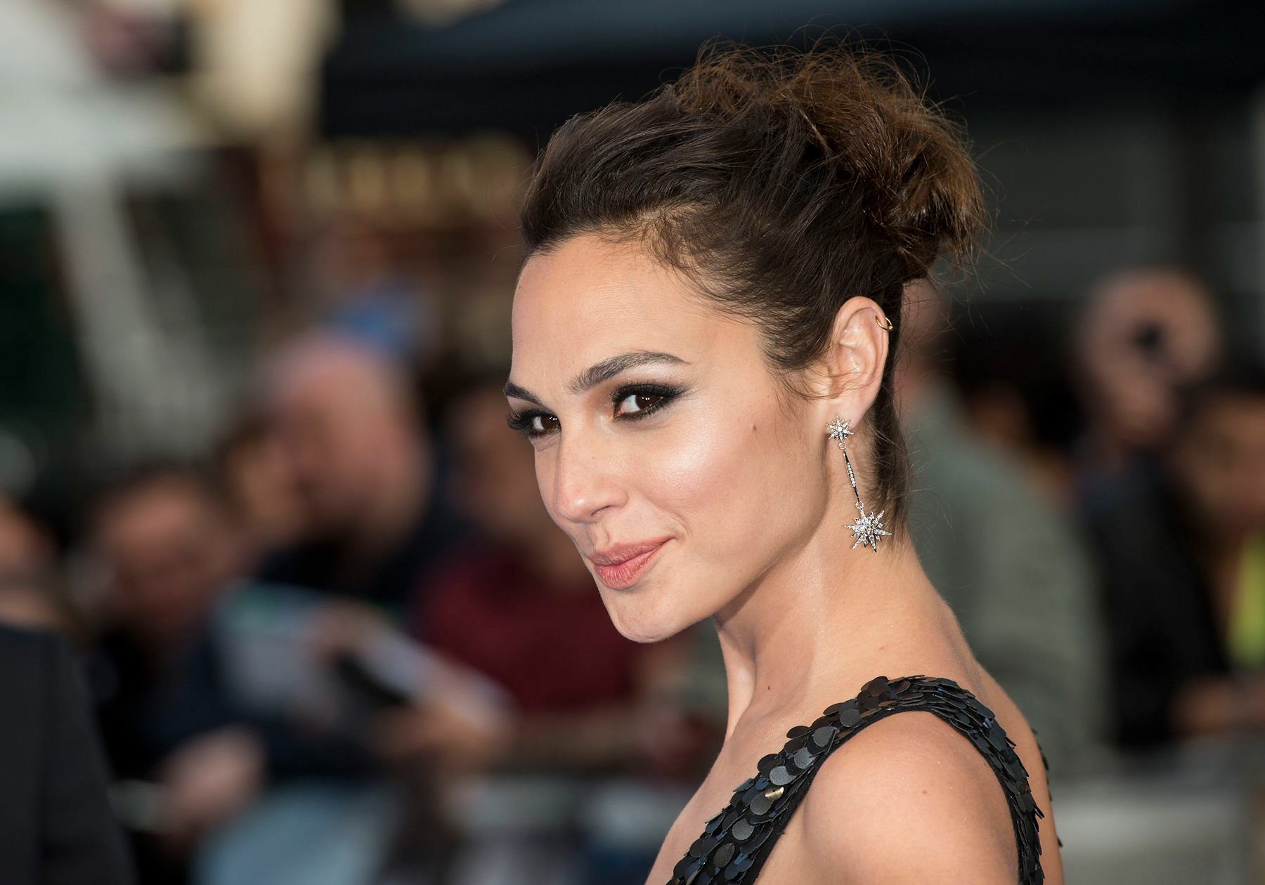 HD PC desktop wallpaper featuring a close-up of celebrity Gal Gadot with an elegant updo and subtle makeup at a public event.
