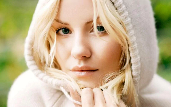 A close-up of Elisha Cuthbert wearing a cozy hooded sweater, showcasing her natural beauty with soft lighting and a serene background, perfect as a HD desktop wallpaper.