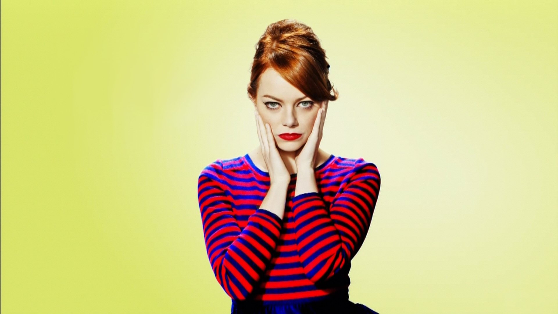 Emma Stone poses thoughtfully against a soft yellow background, wearing a striped shirt. This vibrant HD image serves as a stylish desktop wallpaper.
