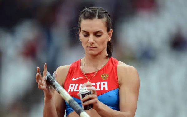 Yelena Isinbayeva in a red and blue Russia sports uniform, preparing for a pole vault event, captured in a high-definition PC desktop wallpaper.