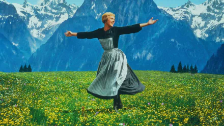 HD desktop wallpaper of a scene from the movie The Sound of Music, featuring a woman joyfully spinning in a flower-filled alpine meadow with snow-capped mountains in the background.
