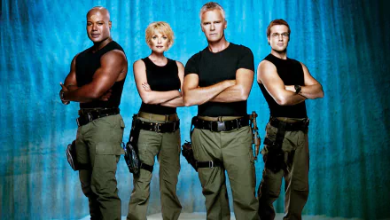 HD PC desktop wallpaper featuring the main cast of the TV show Stargate SG-1 standing confidently against a blue backdrop.