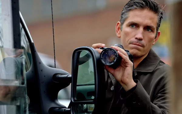 HD PC desktop wallpaper featuring a scene from the TV show Person of Interest, depicting a man intently holding a camera lens by a vehicle.