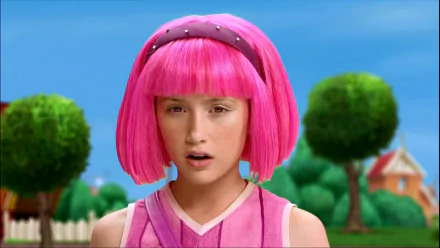 HD PC desktop wallpaper of Stephanie from the TV show LazyTown — close-up of her bright pink bob and pink outfit against a sunny, tree-lined suburban background.