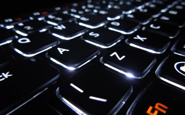 Close-up view of a sleek, illuminated keyboard against a dark background, showcasing the intricate design of technology in a stunning 4K Ultra HD wallpaper.