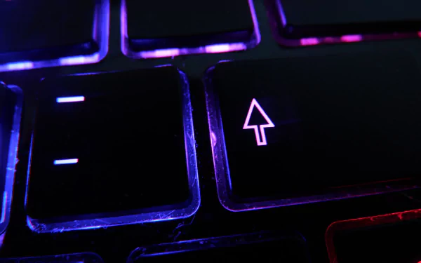 Close-up of a keyboard key with a vibrant illuminated arrow, set against a dark backdrop. This 4K Ultra HD PC desktop wallpaper showcases modern technology.