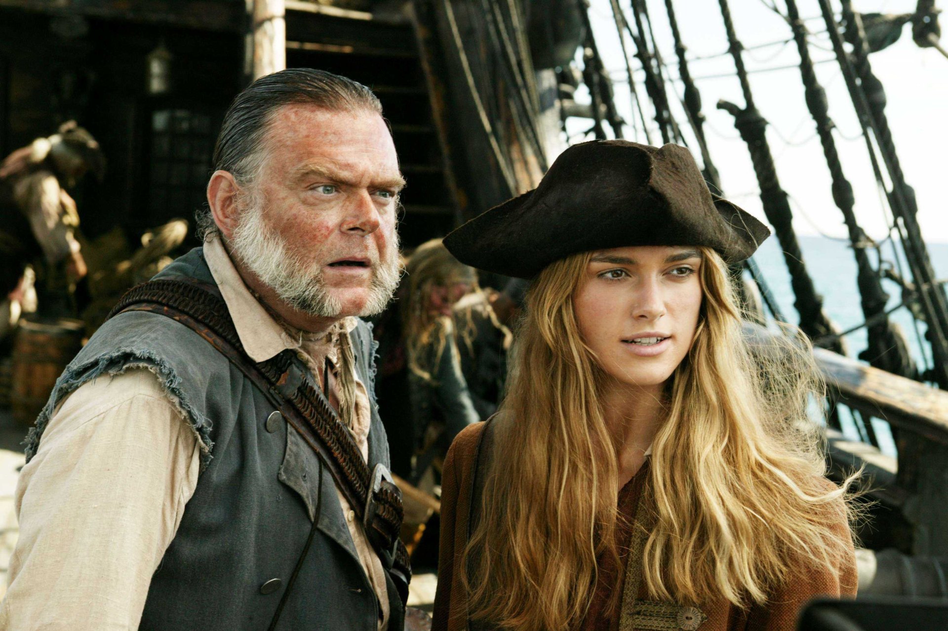 2K Quad HD PC desktop wallpaper: Joshamee Gibbs and Elizabeth Swann on a ship deck from Pirates of the Caribbean: Dead Man's Chest.