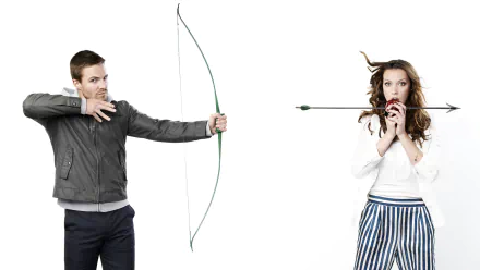 HD PC desktop wallpaper featuring Stephen Amell aiming a bow and arrow at Katie Cassidy, inspired by the TV show Arrow.