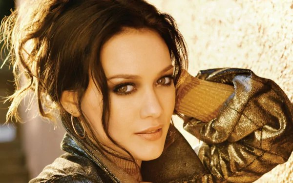 HD PC desktop wallpaper featuring a close-up of celebrity Hilary Duff with soft lighting and a warm, textured background.