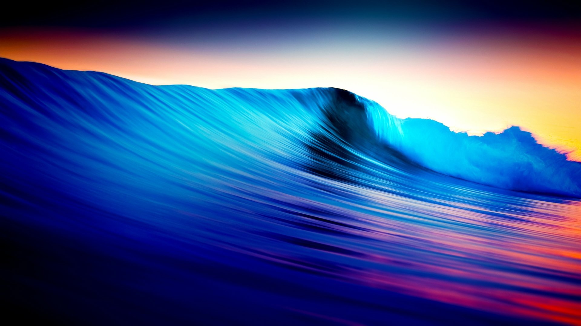 A vibrant, high-resolution 4K Ultra HD wallpaper featuring a dynamic ocean wave at sunset, showcasing rich blues and warm hues for a stunning nature background.