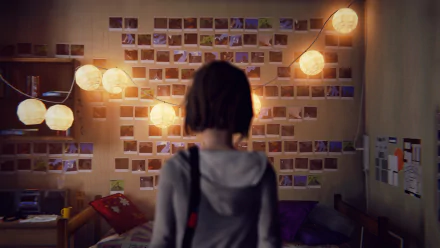 Max Caulfield, from the video game Life Is Strange, stands in a room with a photo-covered wall and hanging lights. This HD desktop wallpaper captures an atmospheric scene from the game.