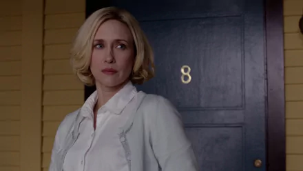 Vera Farmiga stands thoughtfully by a door marked with the number 8, capturing a haunting moment from the TV show Bates Motel in this HD desktop wallpaper.