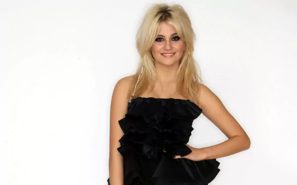Blonde pop singer in a ruffled black dress posing against a white backdrop; music-themed 2K Quad HD PC desktop wallpaper.